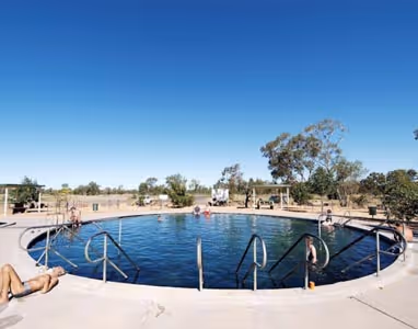 Bore baths in Lightning Ridge with people lounging in the sun.